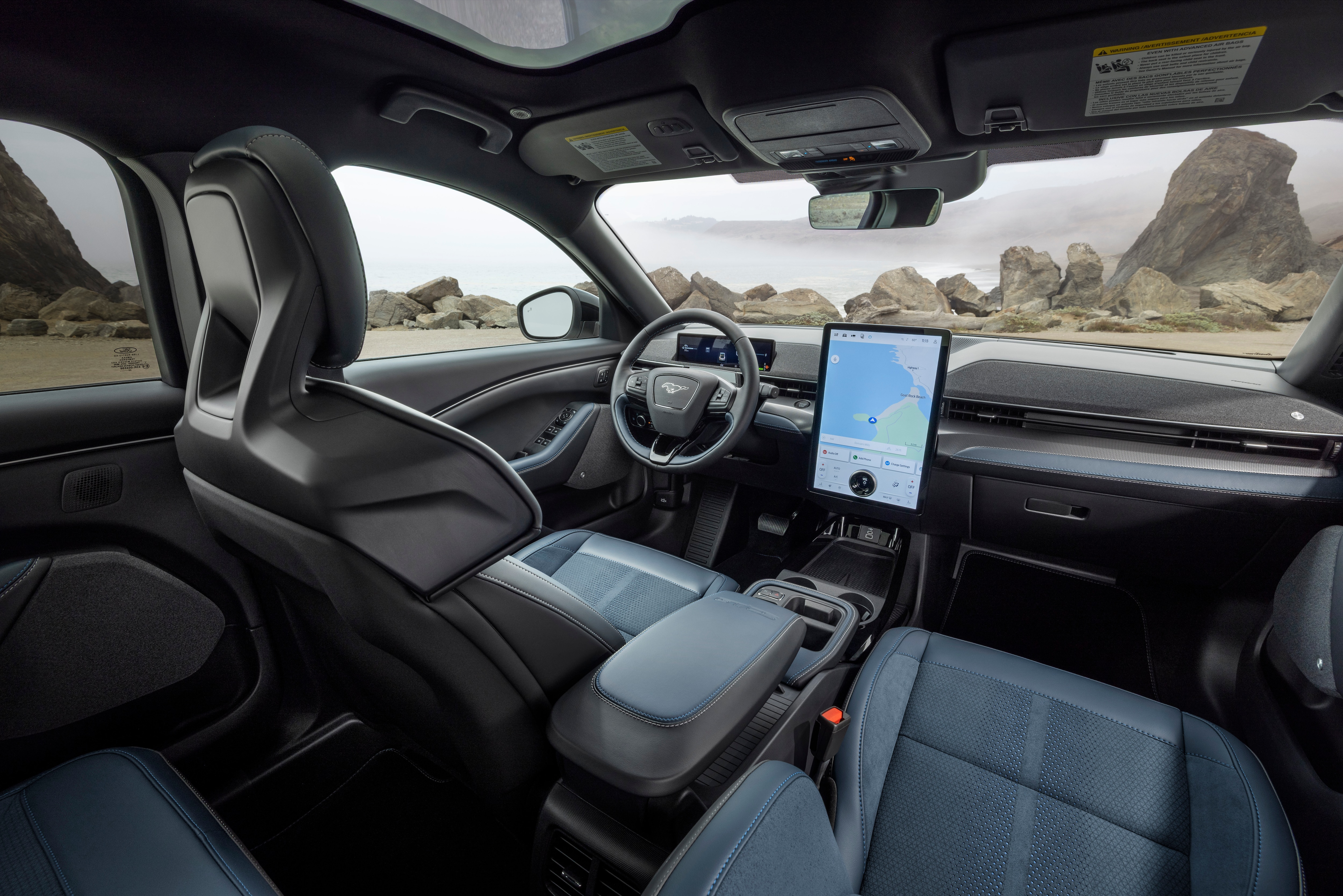 Mustang Mach-E interior from the back seat showing the dashboard and front driver seat.